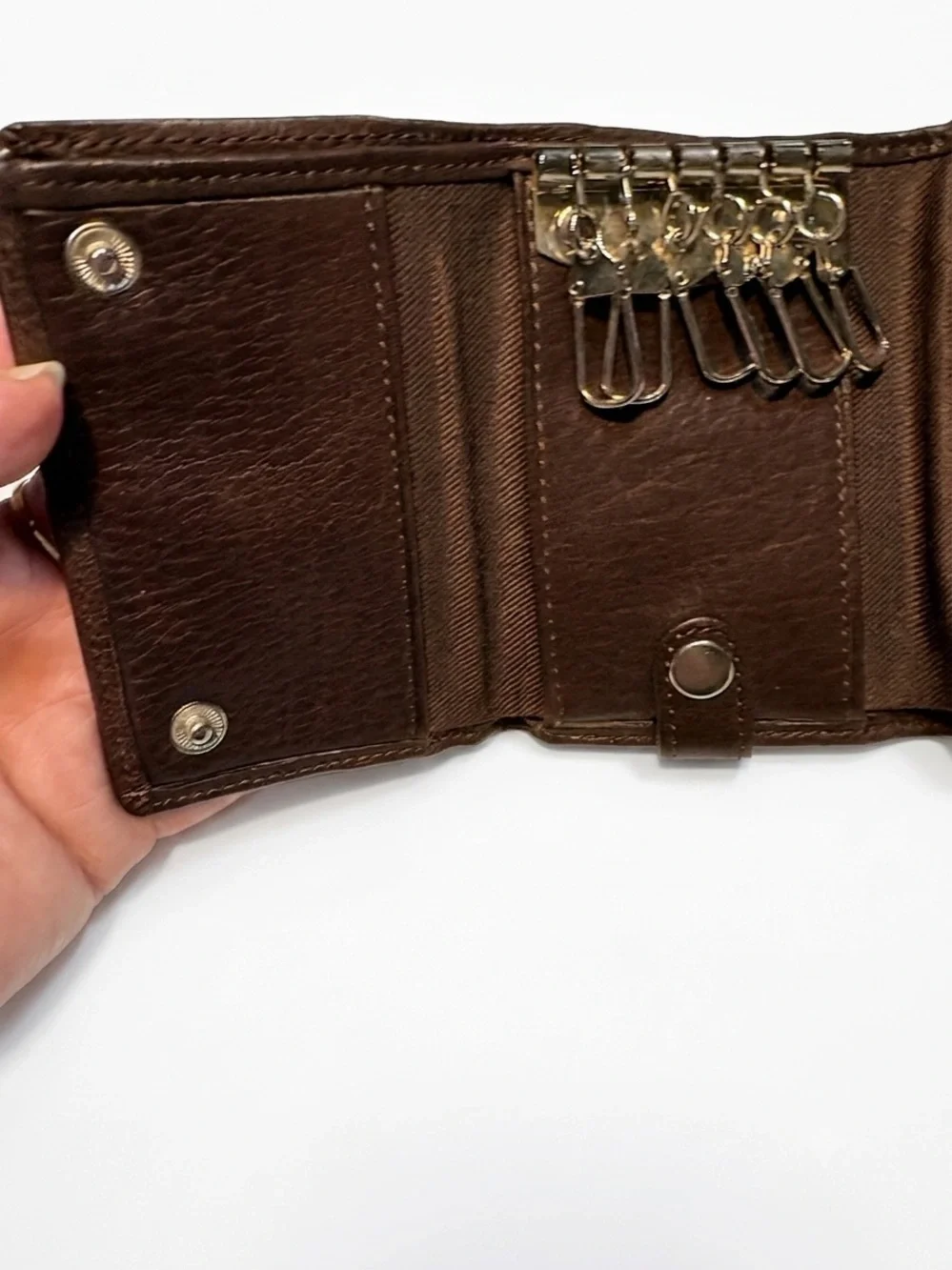 leather Fossil tri-fold key holder wallet featuring six metal key hooks.